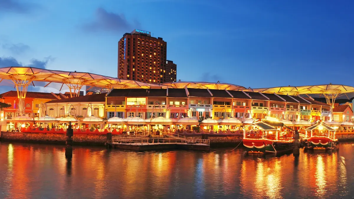 Clarke Quay — Wide view of Clarke Quay at night, its lit riverside buildings and bumboats reflected in the Singapore River