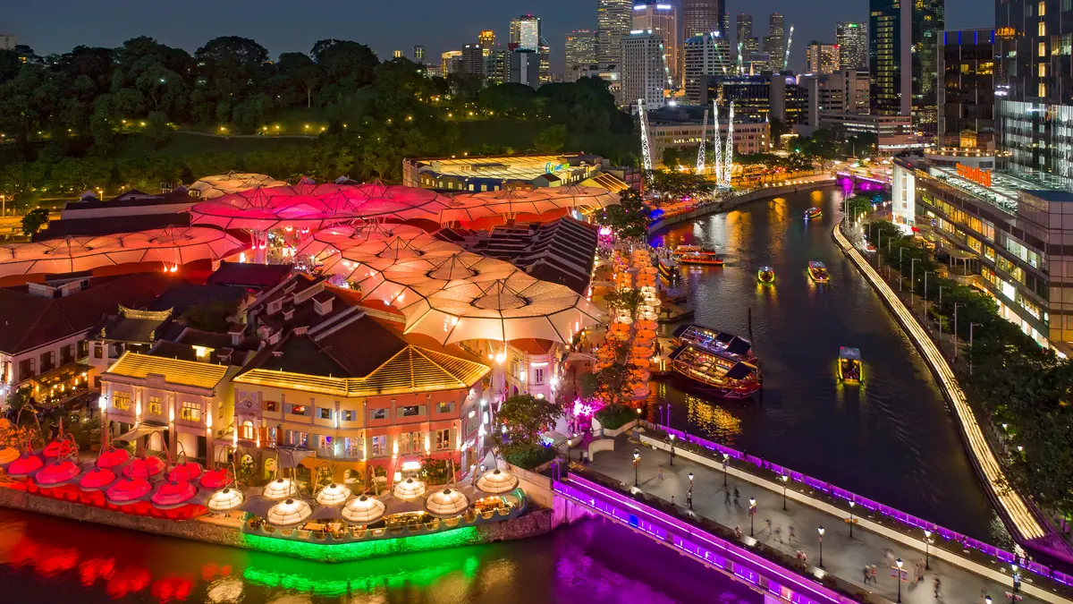 Clarke Quay — Clarke Quay lit in pink and gold at night from above, with the Singapore River running through it