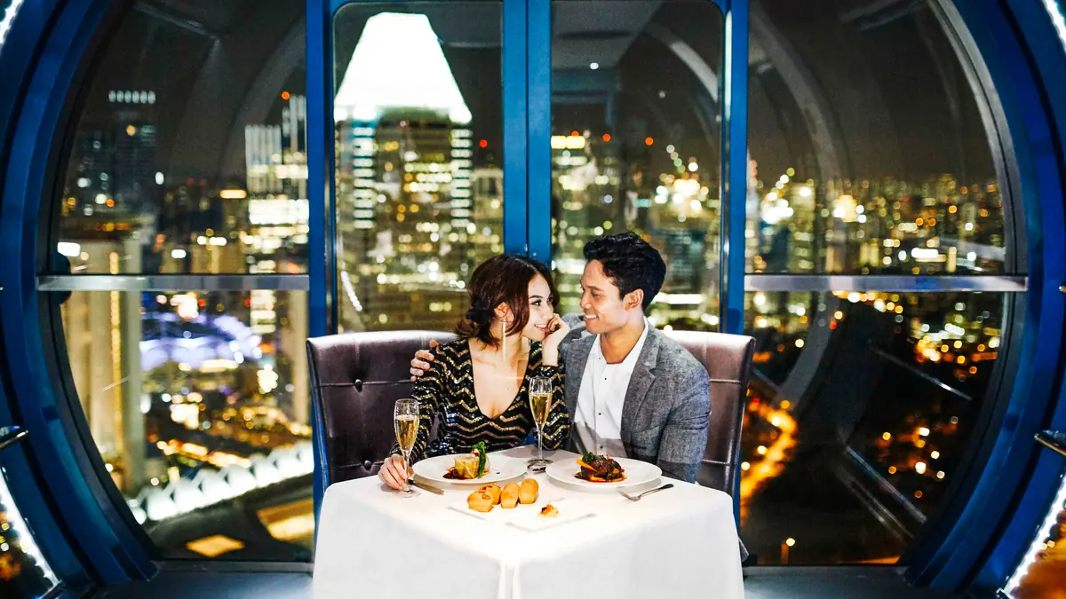 Singapore Flyer — A couple dining at a candlelit table inside a Singapore Flyer capsule above the city lights