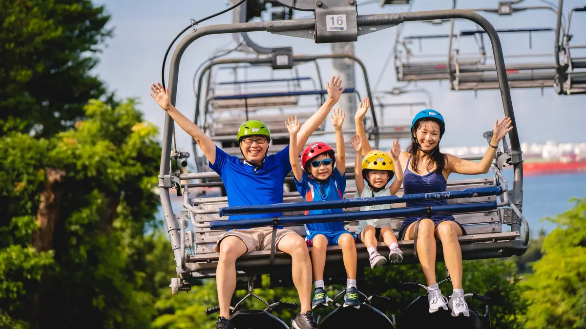 Skyline Luge Singapore — A family riding the Skyline Luge go-carts down the winding track on Sentosa, Singapore