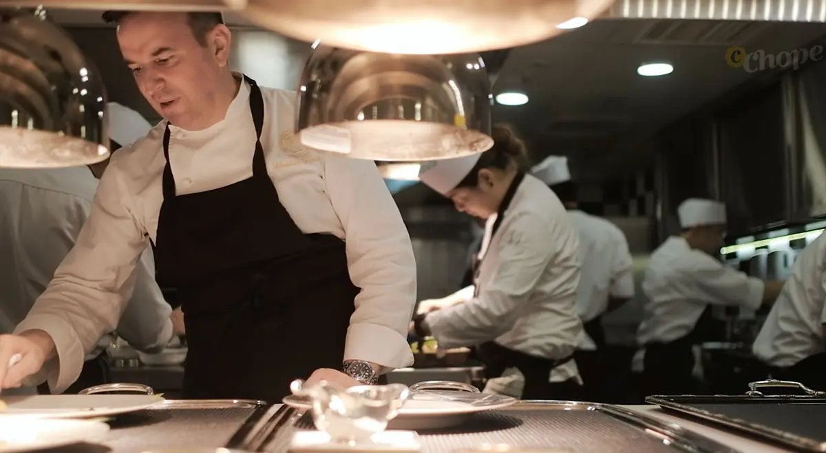 Chef plating under silver cloches in the Les Amis kitchen, Singapore
