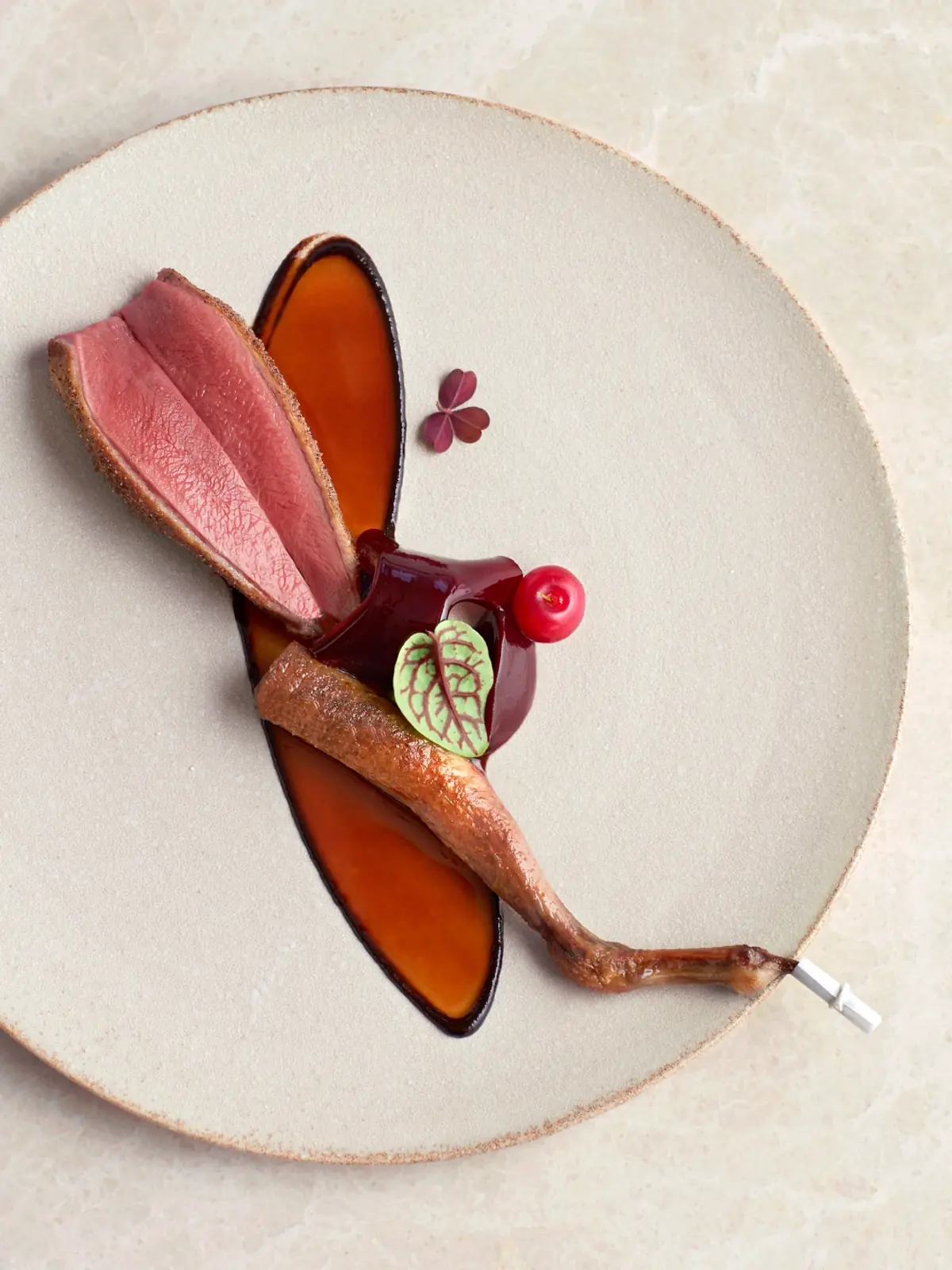 Kampot pepper-crusted pigeon plated at Odette, Singapore