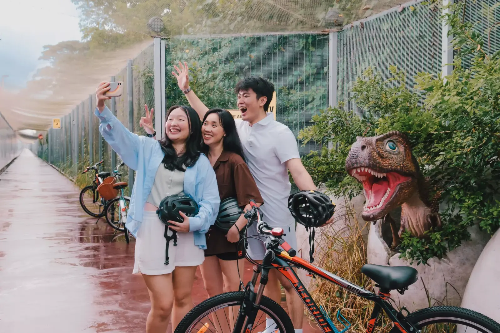 Changi Airport — Cyclists pausing for a photo among dinosaur replicas along Changi Jurassic Mile