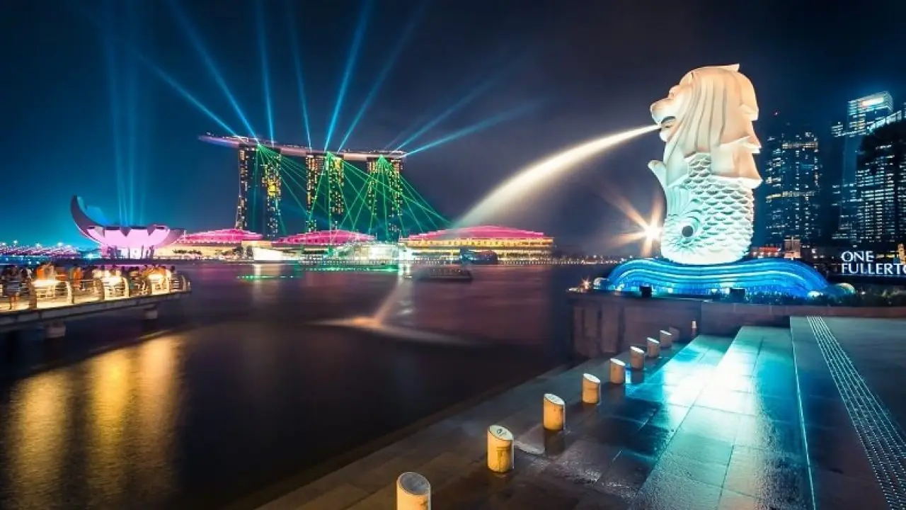 Marina Bay Singapore at night with the light and water show, Marina Bay Sands and the Helix Bridge in view