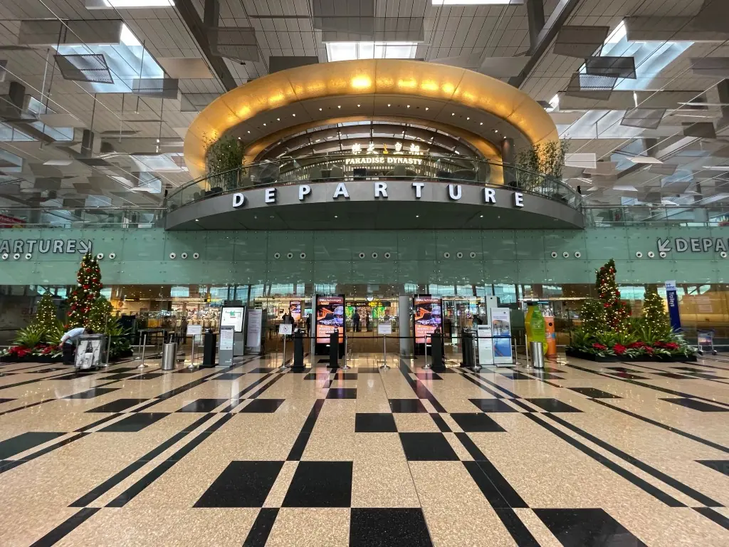 Passengers walking through a departure transit hall at Changi Airport Singapore