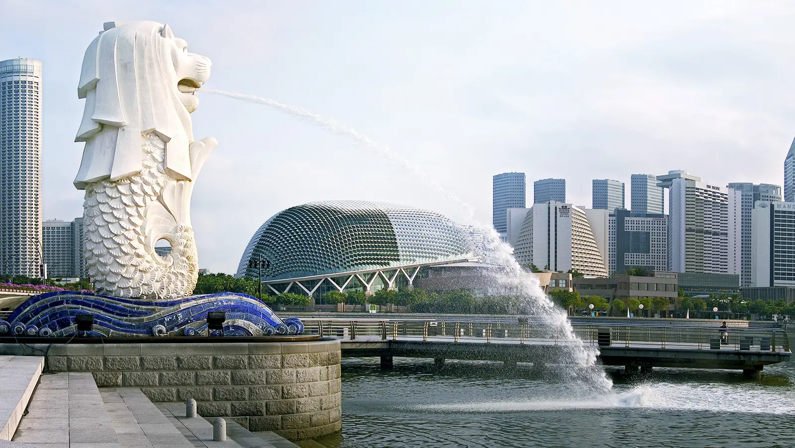 The Merlion statue spouting water at Merlion Park, with the Marina Bay skyline behind it